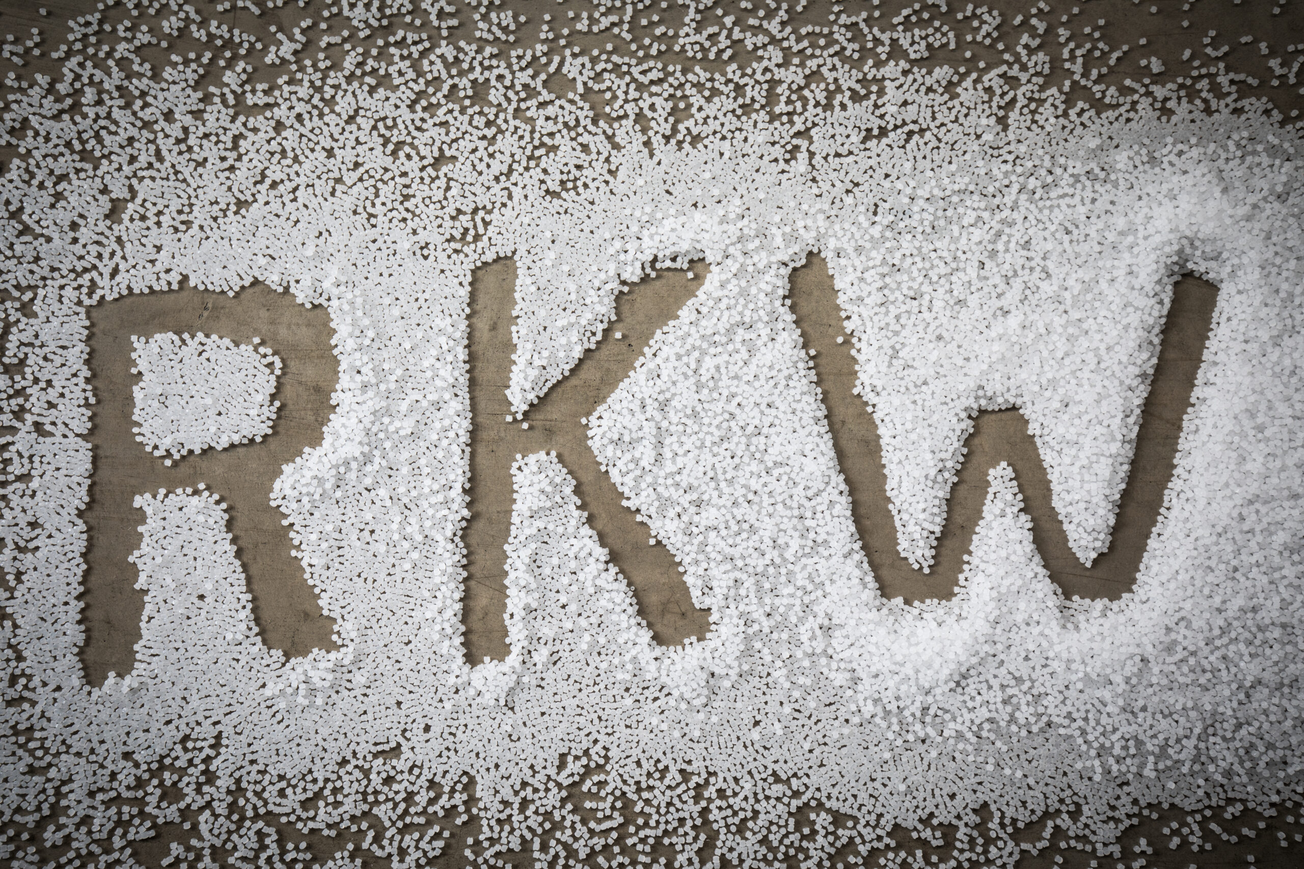 Mit weißem Kunststoffgranulat gestreute Buchstaben „RKW“ auf dem Boden.
